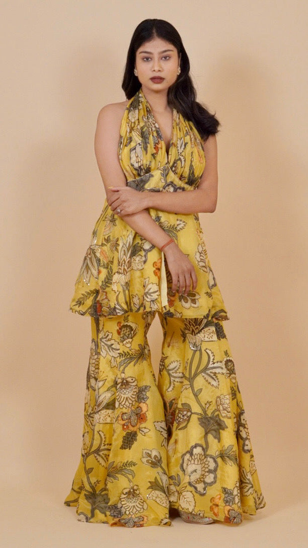 Woman wearing a yellow floral dress against a beige background