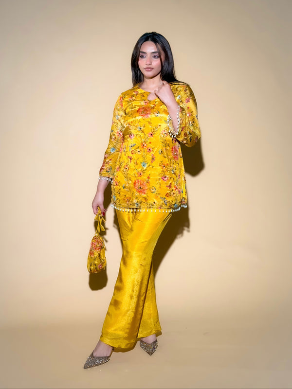 Woman wearing a yellow floral outfit against a beige background
