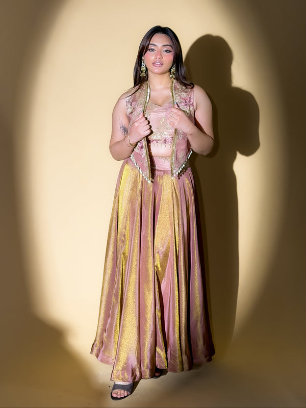 Woman wearing a traditional outfit with a pink and yellow dress against a plain background